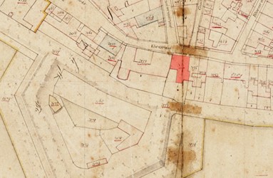 <p>In rood is Koestraat 10 gearceerd op de kadastrale minuutkaart van 1832. Het huis bevindt zich vlakbij het Suikerbergbastion. Er is reeds sprake van een omvangrijk achterhuis tegen de buitenzijde van de middeleeuwse stadsmuur. De maatvoering van dit achterhuis lijkt afgestemd te zijn op de indeling van de voormalige verdedigingswerken. De diepte van de ruimte tussen stadsmuur en voormuur komt namelijk overeen met de diepte van het achterhuis op het minuutplan van 1832 en de bebouwing springt aan de achterzijde in ter hoogte van het voormalige rondeel (www.watwaswaar.nl). </p>
